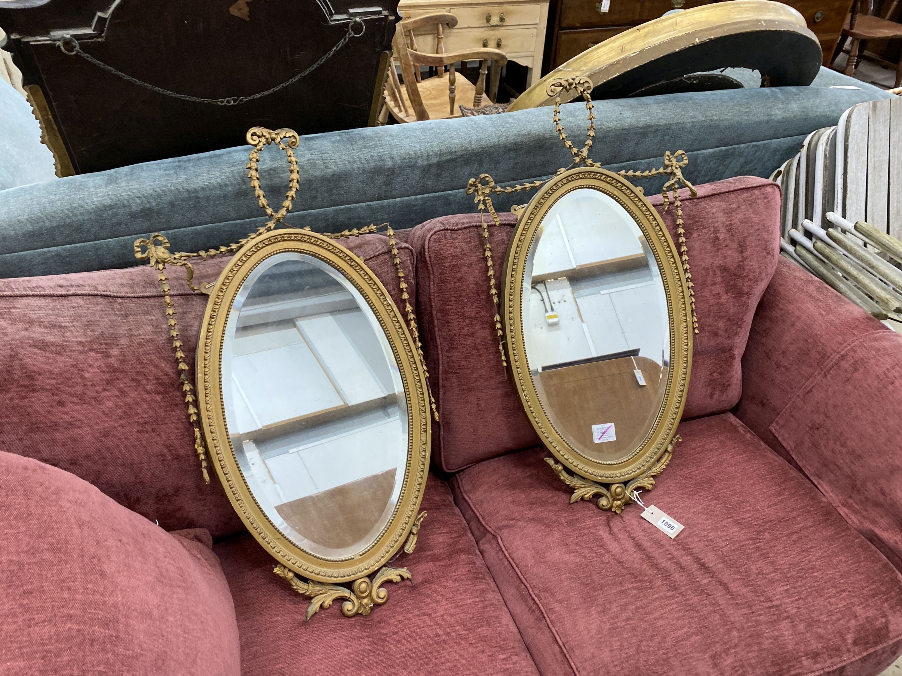 A pair of Edwardian Adam design oval giltwood and gesso wall mirrors, width 43cm, height 80cm